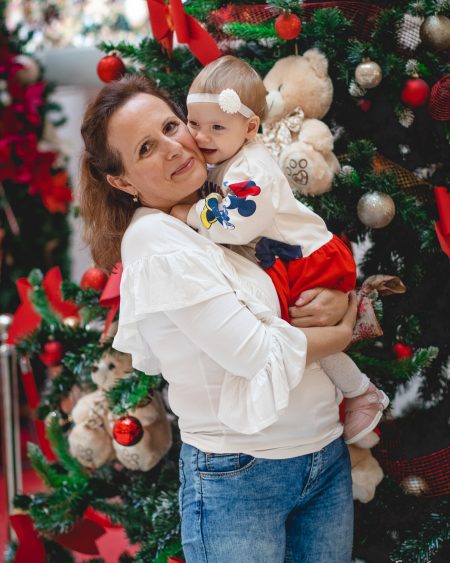 Майка целува бебето за коледа.