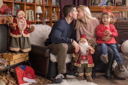 Семейна целувка в коледния декор.